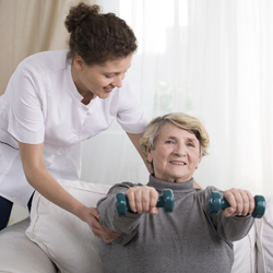 assisting elderly woman with exercises