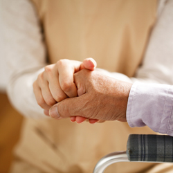 Close up of person holding senior person’s hand