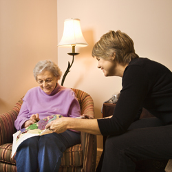 Woman assisting an older woman with her needlework