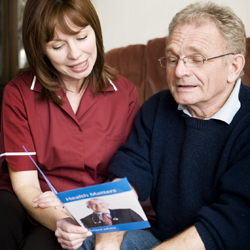 Personal care worker reading with older man