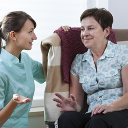 Health care worker talking with patient in her home