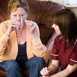 Care worker giving medication to client
