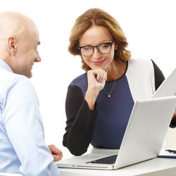 Two workers at a table looking at information on a computer