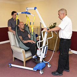 Man and woman lifting a man in a hoist