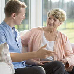 Male care worker talking to an older woman