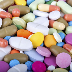 A pile of pills in different shapes, sizes and colours