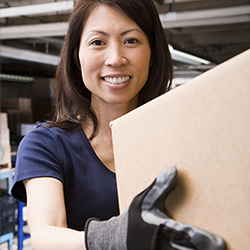 Woman wearing gloves holding a cardboard box