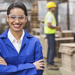 Smiling woman wearing protective goggles in a warehouse
