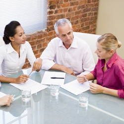 Colleagues seated around a table having a meeting