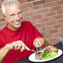 Smiling senior man eating a meal