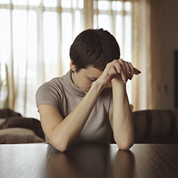Woman with elbows on table and head on hands