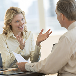 Woman sitting opposite man and gesturing with her hands