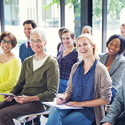 Group of multi-ethnic people in a classroom taking notes