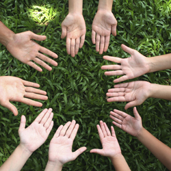 A group of people with their hands in a circle with their palms facing up