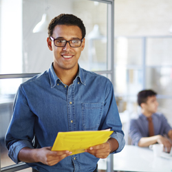 Smiling man holding a document in office