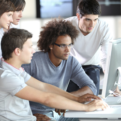 Group of people at a computer in a training course